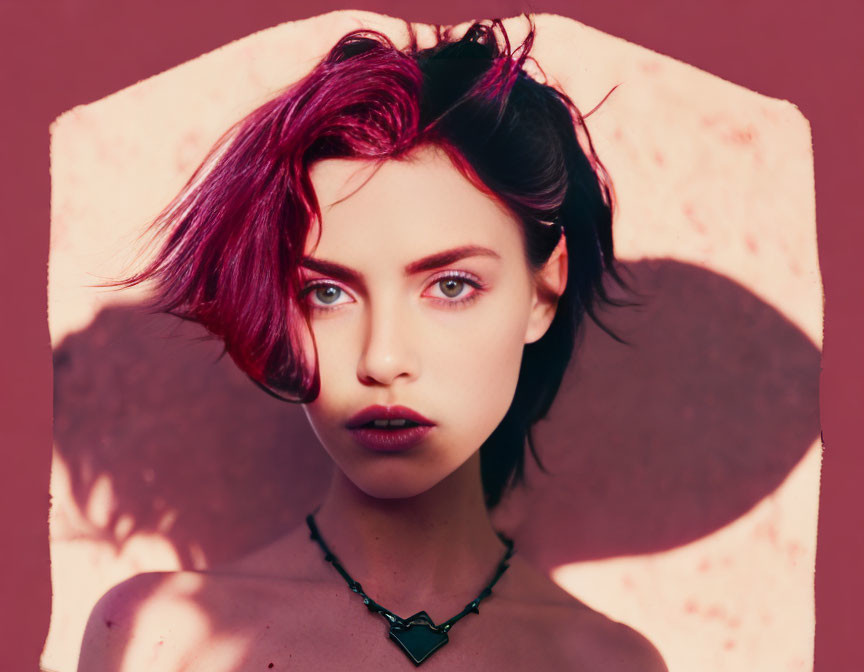 Burgundy-haired woman with blue eyes on pink background with shadow