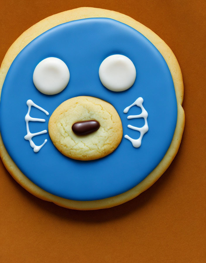 Whimsical cookie with blue icing face and candy nose