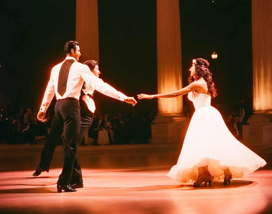 Elegant man and woman dancing in formal attire under warm stage lighting