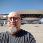 Elderly man portrait collaged with modern building on blue sky