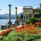 Sculpted hedges, colorful flowers, cypress trees in lakeside garden