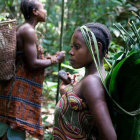 Children in forest with traditional clothing and backpacks carrying younger child