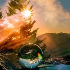 Layered mountains, reflective sea, large planet, sunset sky in fantastical landscape