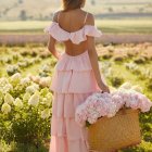 Blond woman in pink dress among yellow flowers