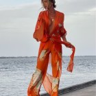 Stylish orange patterned jumpsuit with collar on woman by the sea