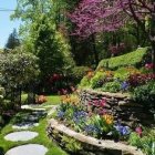 Tranquil garden with waterfall, stepping stones, pink trees, and pond