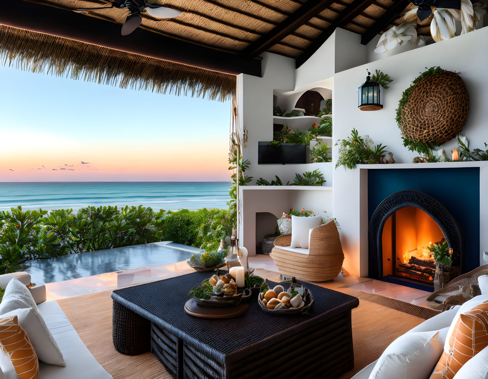 Elegant seaside balcony with cozy seating, fireplace, plants, and sunset ocean view