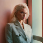 Blonde woman in fur coat against pastel wall exudes elegance