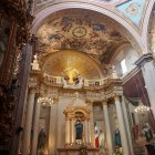 Luxurious Baroque interior with gold and peacock motifs, ornate staircases, and vibrant trees