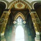 Intricate geometric patterns in ornate arched hallway with glowing figure