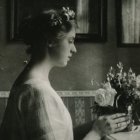 Monochromatic image: Woman with flowers, gazing at reflection in window, stars in dark sky