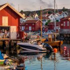 Colorful boats and red huts by calm water with quaint houses in soft light