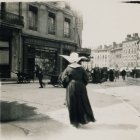 Nuns walking on wet cobblestone street in old town with historic buildings.