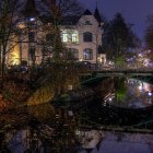 Traditional houses and boats on serene canal at night