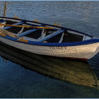 Rusty rowboat on tranquil water under blue sky