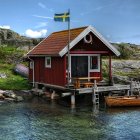 Red Wooden Cabin on Pier with Flags and Yellow Kayak in Clear Blue Water