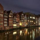 Serene canal at twilight with illuminated historical buildings reflected