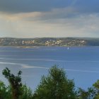 Tranquil lake in lush forest under dramatic sky