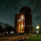 Historic building at night with starry sky and trees.