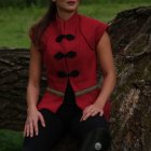 Stylized image of woman with blue hair and red highlights in corset against stone wall