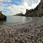 Unique Rock Formations and Serene Beach Scene with Blue Water and Cloudy Sky