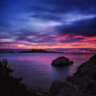 Colorful Twilight Sky Over Tranquil Sea with Silhouetted Island and Lighthouse