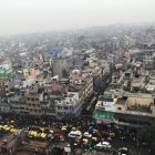 Crowded cityscape with towering spires and hazy sky