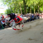 Traditional samurai armor on white horse passing historical Japanese attire row