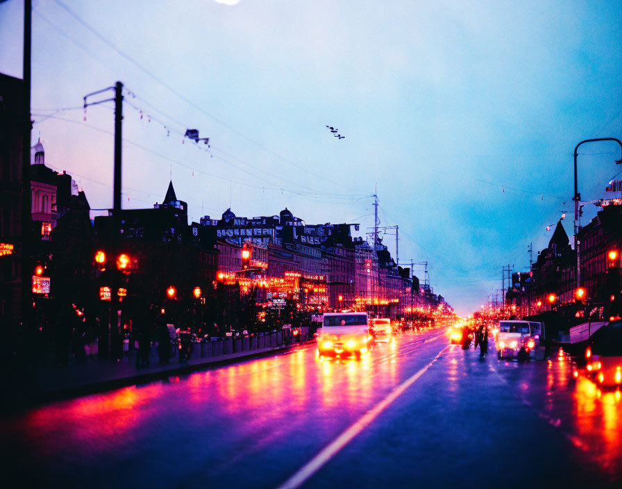 Urban cityscape at twilight with glowing street lights, wet road reflections, and silhouetted buildings