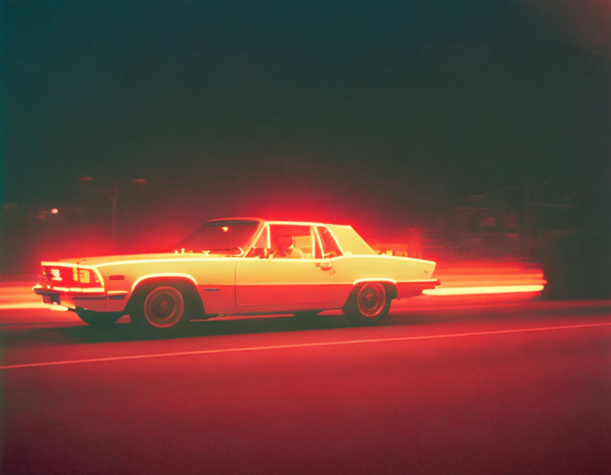 Vintage car night drive with red streak of light