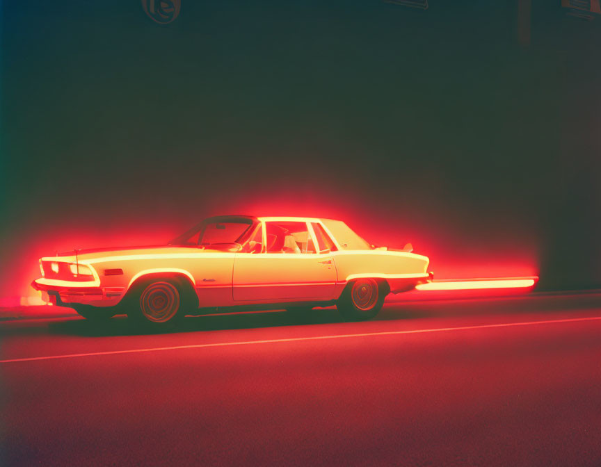 Vintage car under red neon light with motion blur on dark background