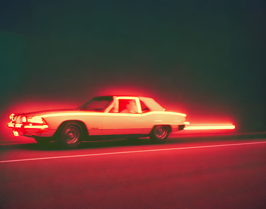 Vintage car with red streaks speeding at night