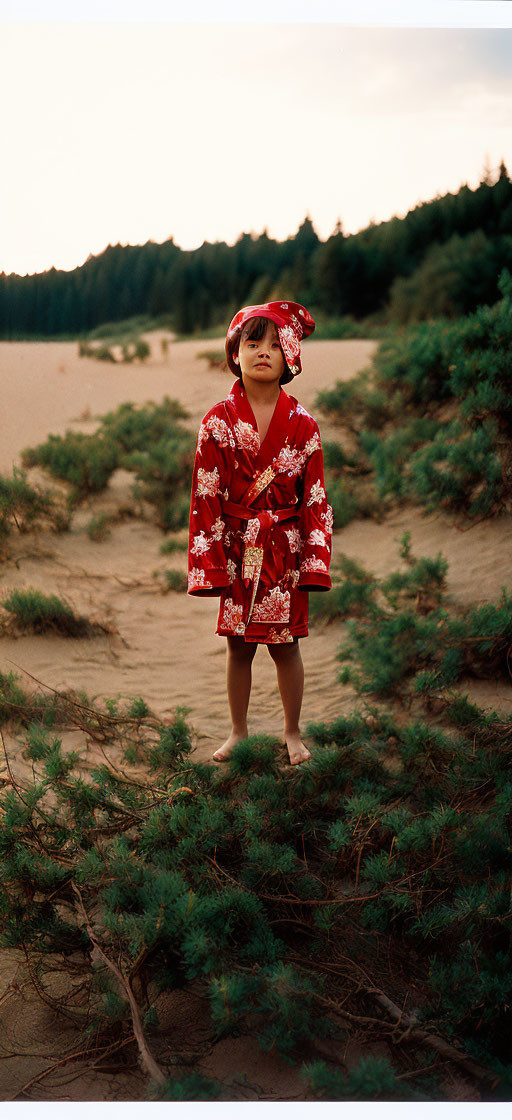 Child in Red Kimono Standing Barefoot in Nature