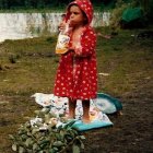 Child in Red Kimono Standing Barefoot in Nature