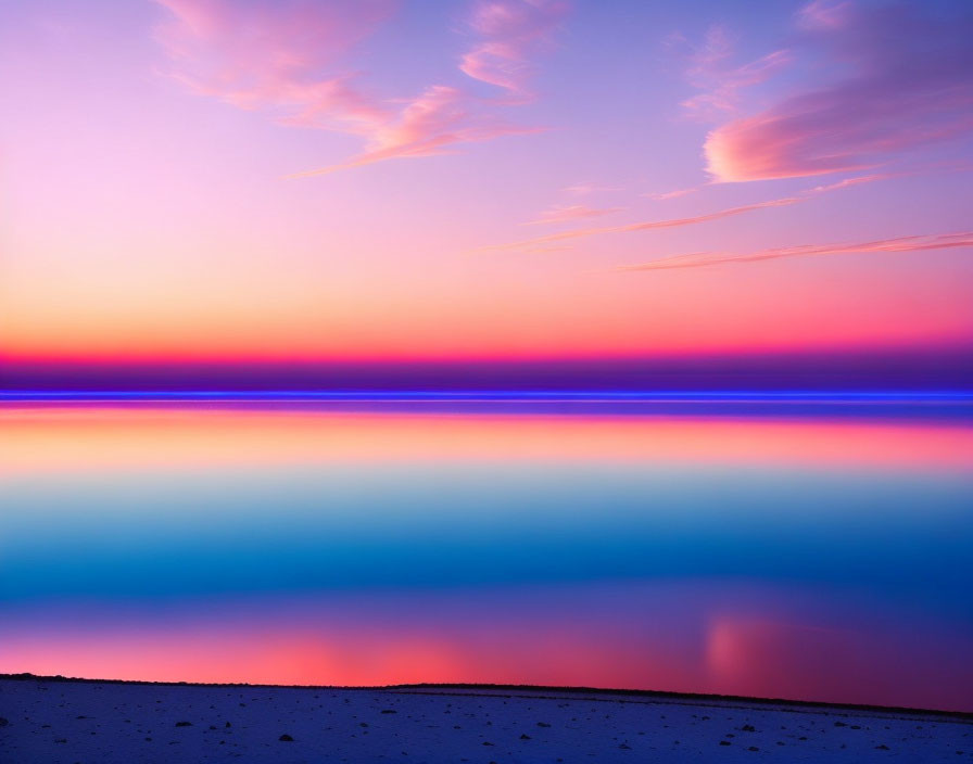 Vibrant sunset skies reflecting on still water with dark shoreline