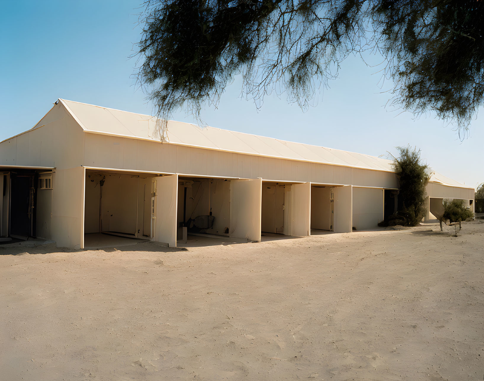 Beige tent with open entrances in sandy landscape