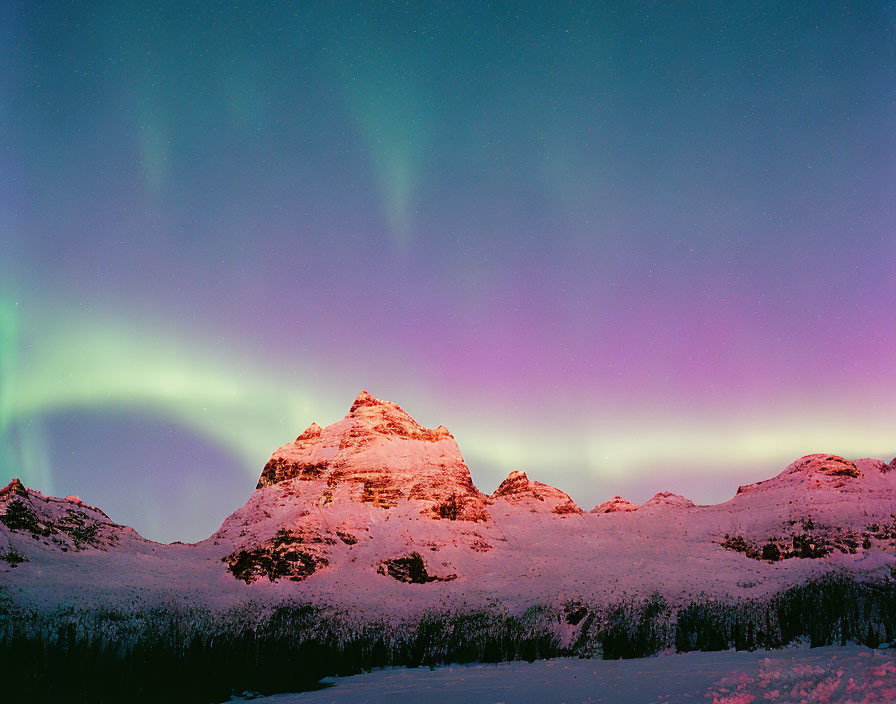 Northern Lights Illuminate Snowy Mountains at Twilight