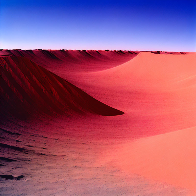 Vibrant red sand dunes under deep blue sky in desert landscape