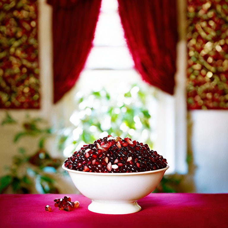 Red kidney beans in a bowl on pink tablecloth with red and gold curtains, greenery.