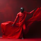 Dynamic dancer twirls in flowing red outfit against moody backdrop