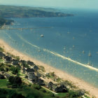 Coastal Village with Sandy Beach, Boats, and Green Landscape