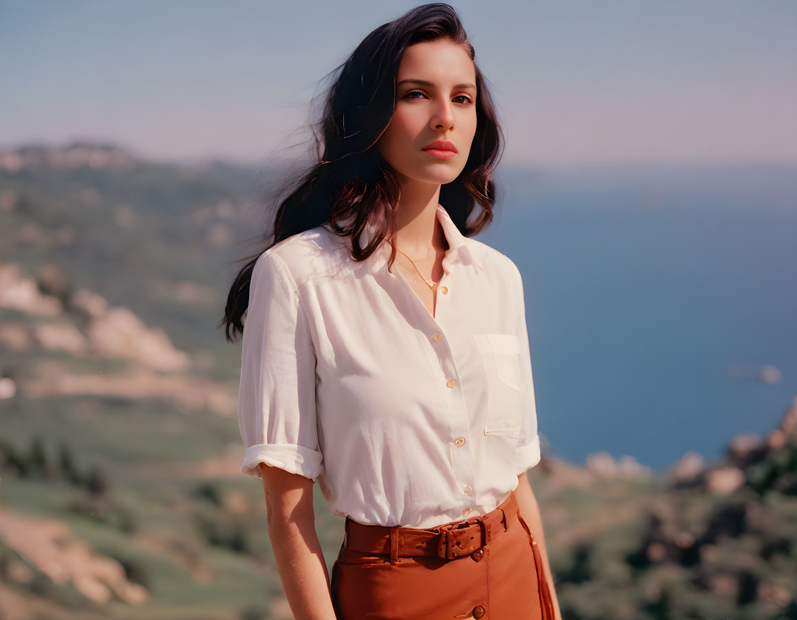 Woman in white blouse with brown belt against serene seascape