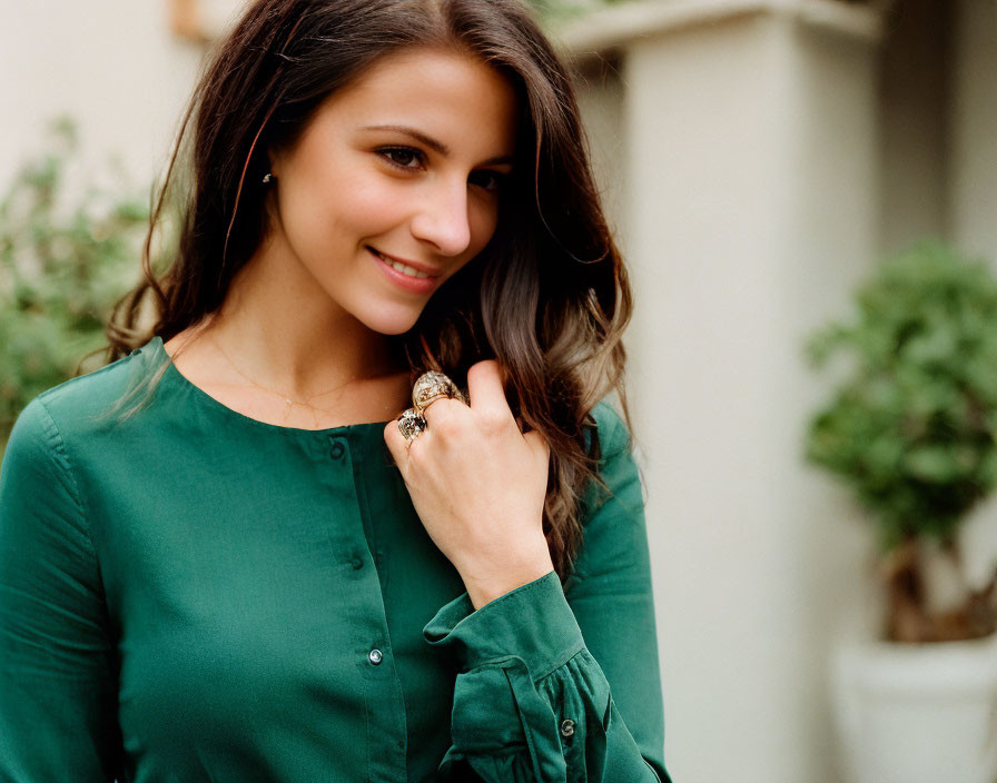 Smiling woman in green blouse with long hair in garden scene