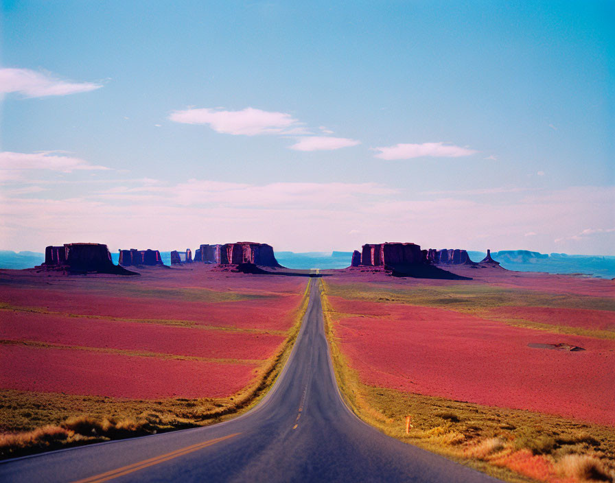 Straight Road to Distant Red Rock Formations in Desert Landscape