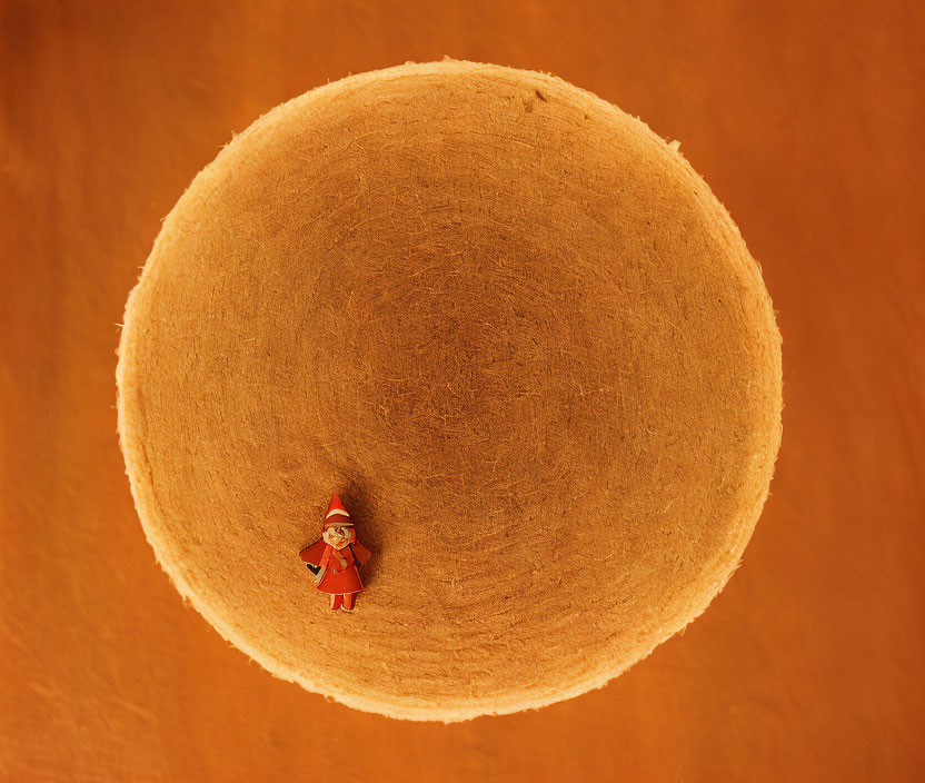 Miniature Santa Claus figure on tan fuzzy texture creates cavernous illusion