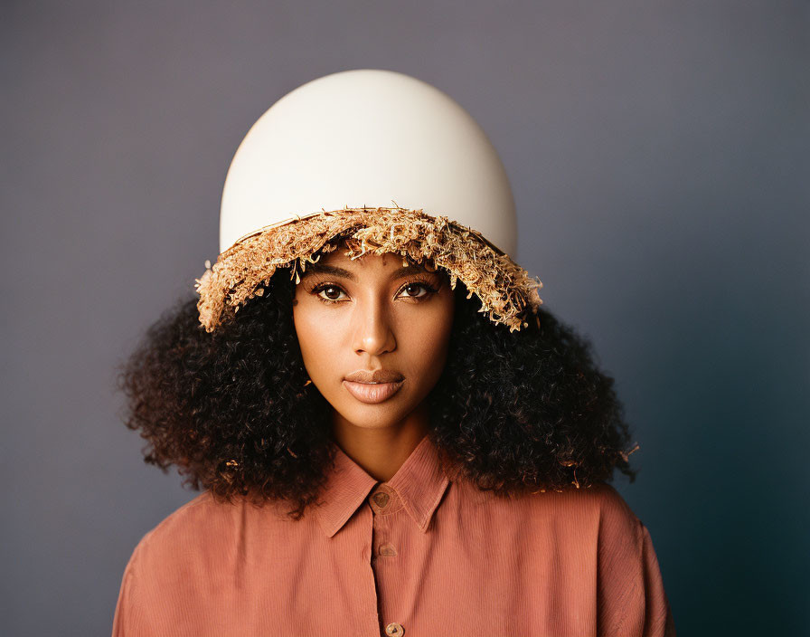 Curly-Haired Woman in Eggshell Hat on Blue Background