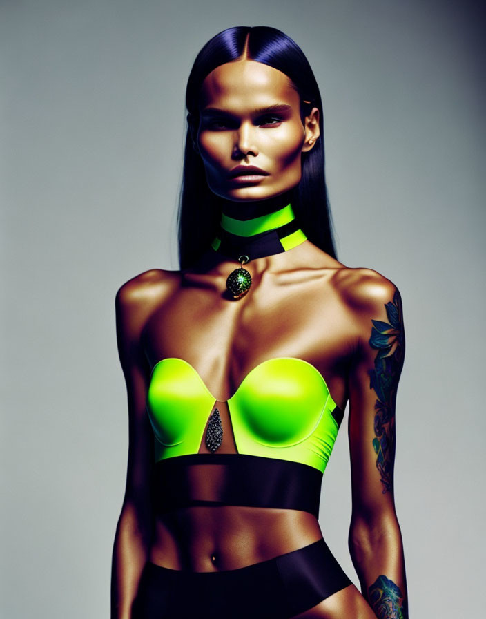 Woman with sleek hair, neon green accents, choker, and arm tattoo in pose.