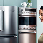 Modern kitchen with stainless steel appliances and blue-lit wall oven