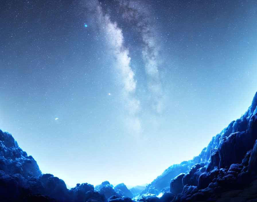 Starry night sky over silhouetted mountains in canyon