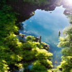 Tranquil river fishing scene with three people in clear water